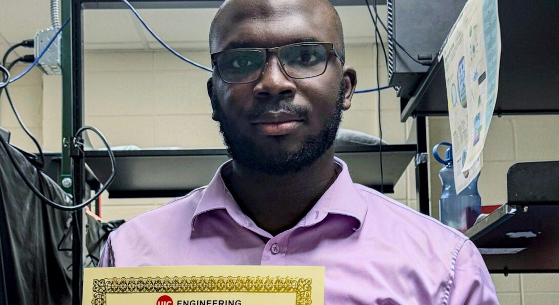 Tobiloba Adejumo holding the “UIC College of Engineering Exceptional Research Promise Award” certificate in a campus lab, May 3 2024